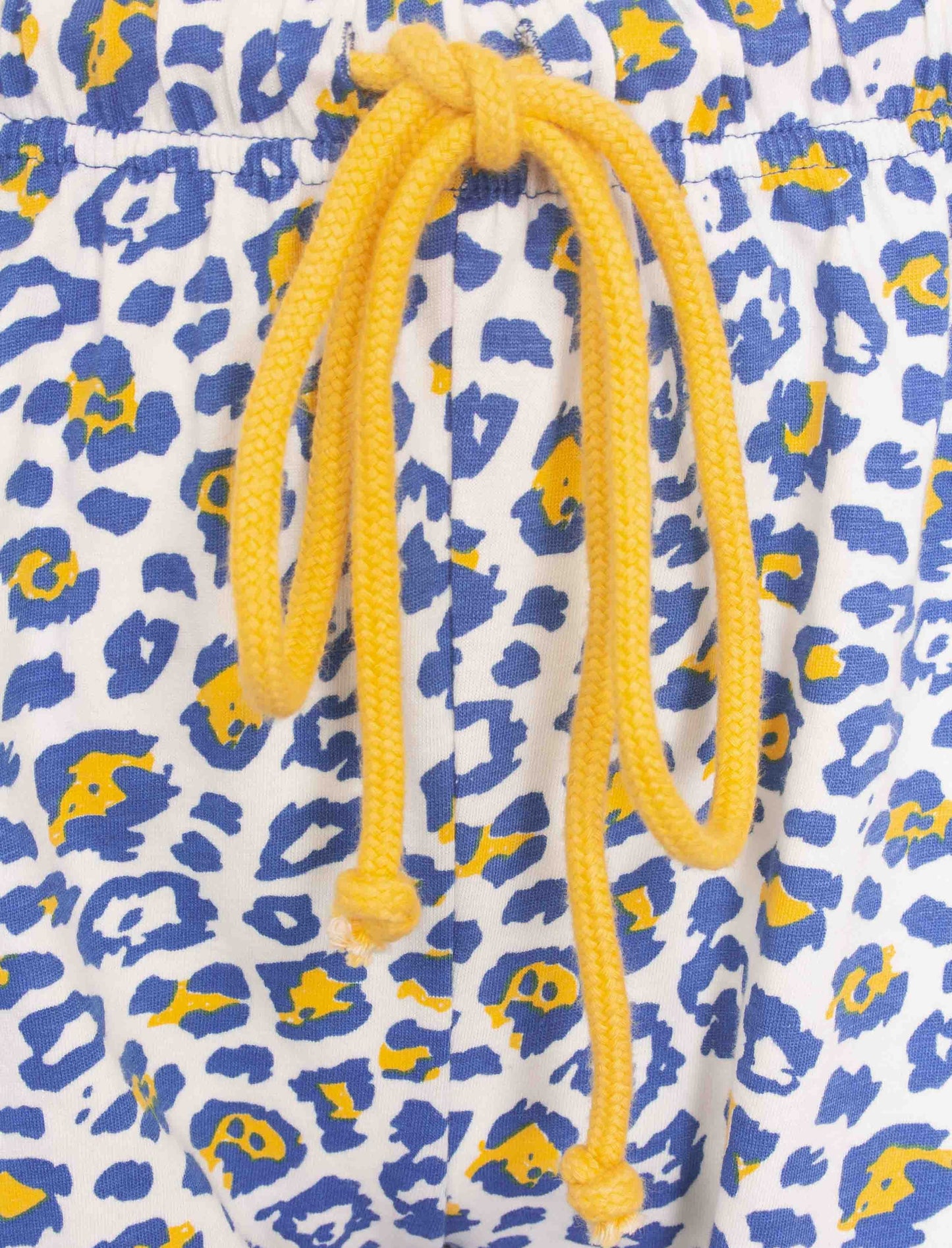 Dames pyjama met blauw-gele panterprint en geel koord. Close-up van stof en aantrekkoord.