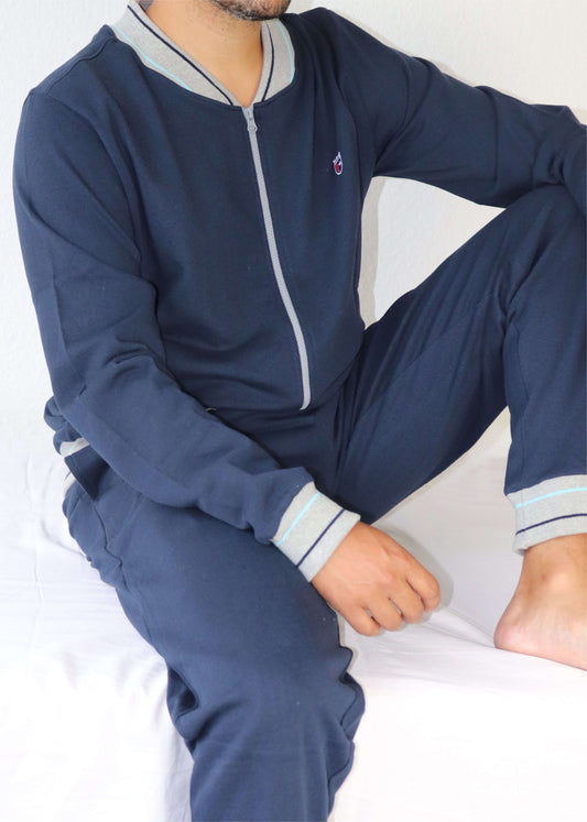 Donkerblauw huispak voor heren met grijze details, sportief model met ritssluiting en een klein logo op de borst.