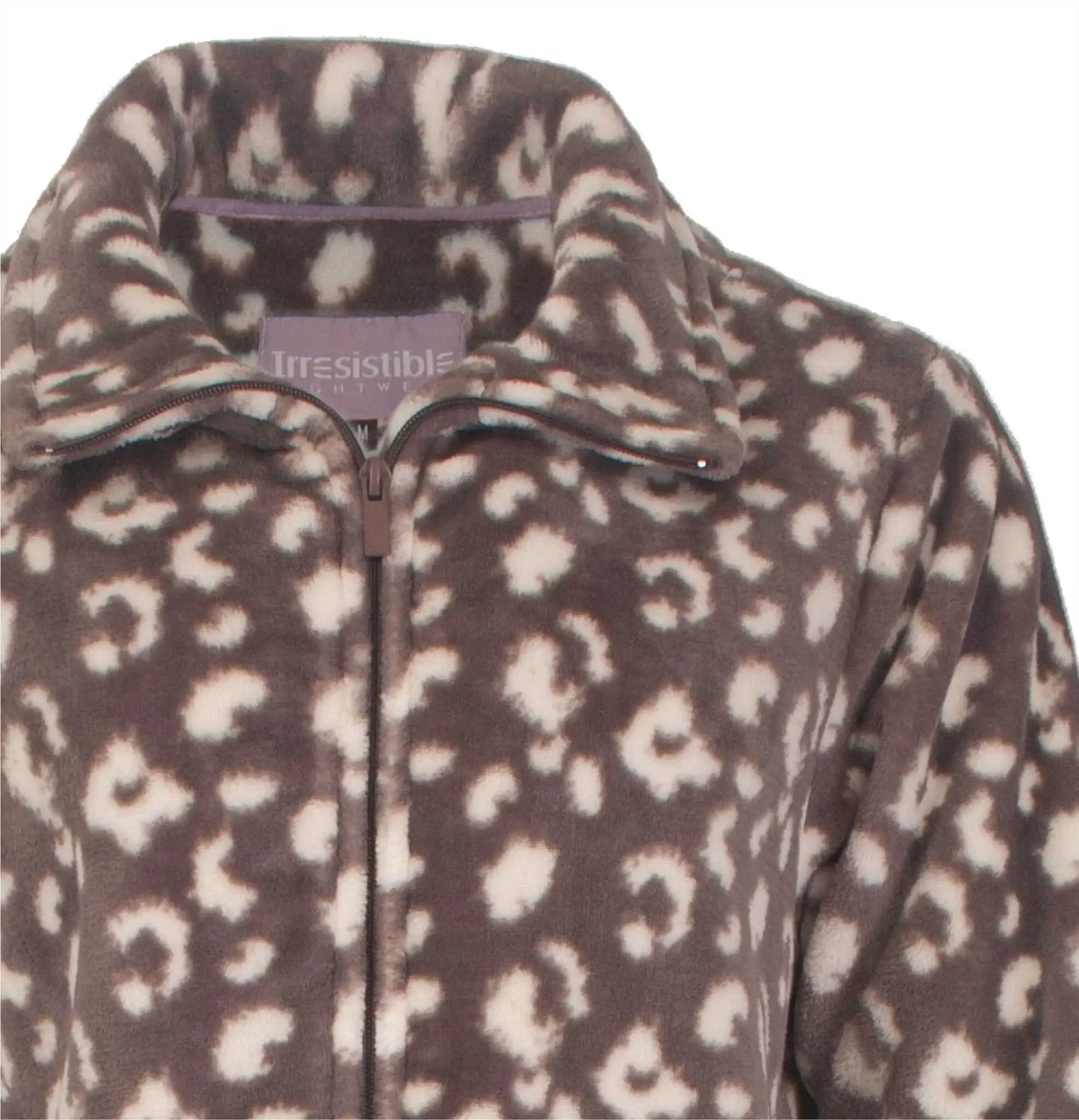 Bruine fleece huispak met panterprint, close-up van de halsopening met rits en 'Irresistible' label.
