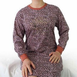 Roze nachthemd met lange mouwen en panterprint, gemaakt van katoen, op een wit oppervlak.