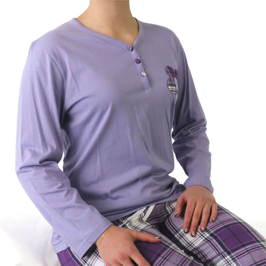 Lila flanellen pyjama top met lange mouwen en knoopsluiting, gedragen met geruite pyjamabroek in paarse tinten.