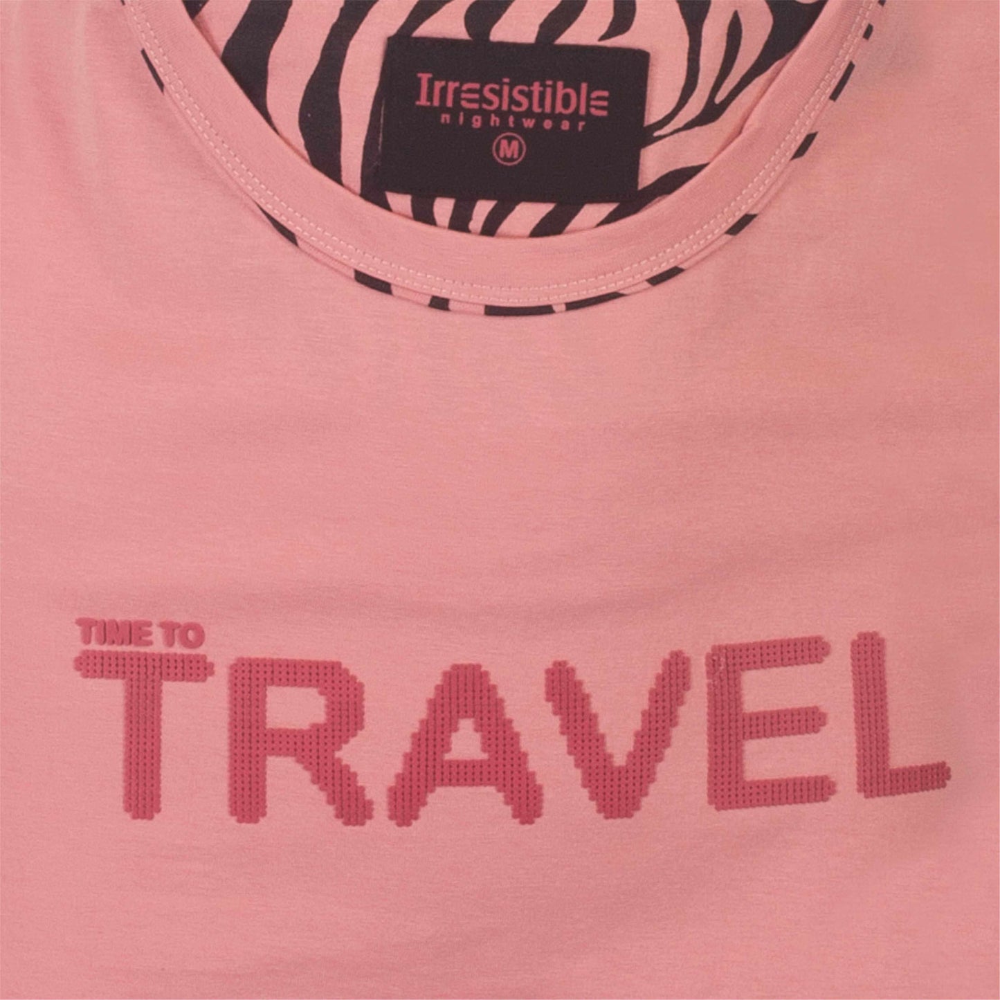 Roze pyjama top met 'Time to Travel' tekst en zwart-wit zebra print kraag. Irresistible merk label zichtbaar.