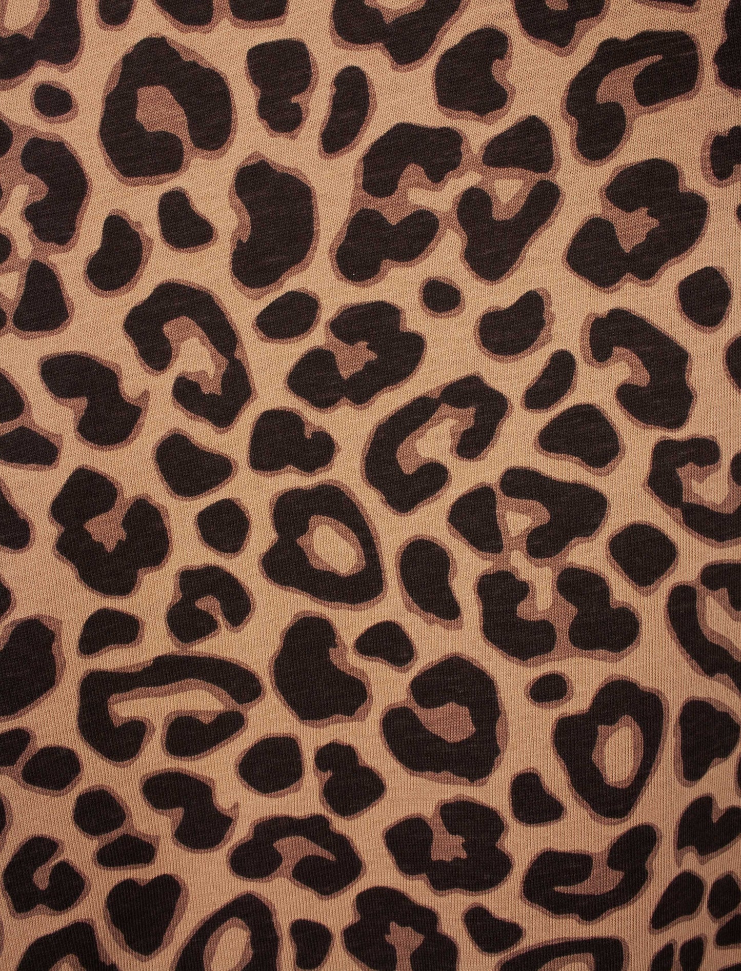 Close-up van bruine stof met zwart luipaardprint patroon, toont textuur van gekamde katoen jersey.