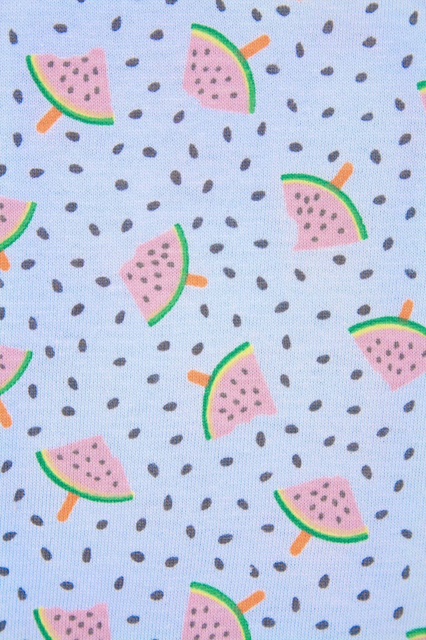 Lichtblauwe pyjamastof met patroon van roze watermeloenschijfjes en zwarte pitjes verspreid over het oppervlak.