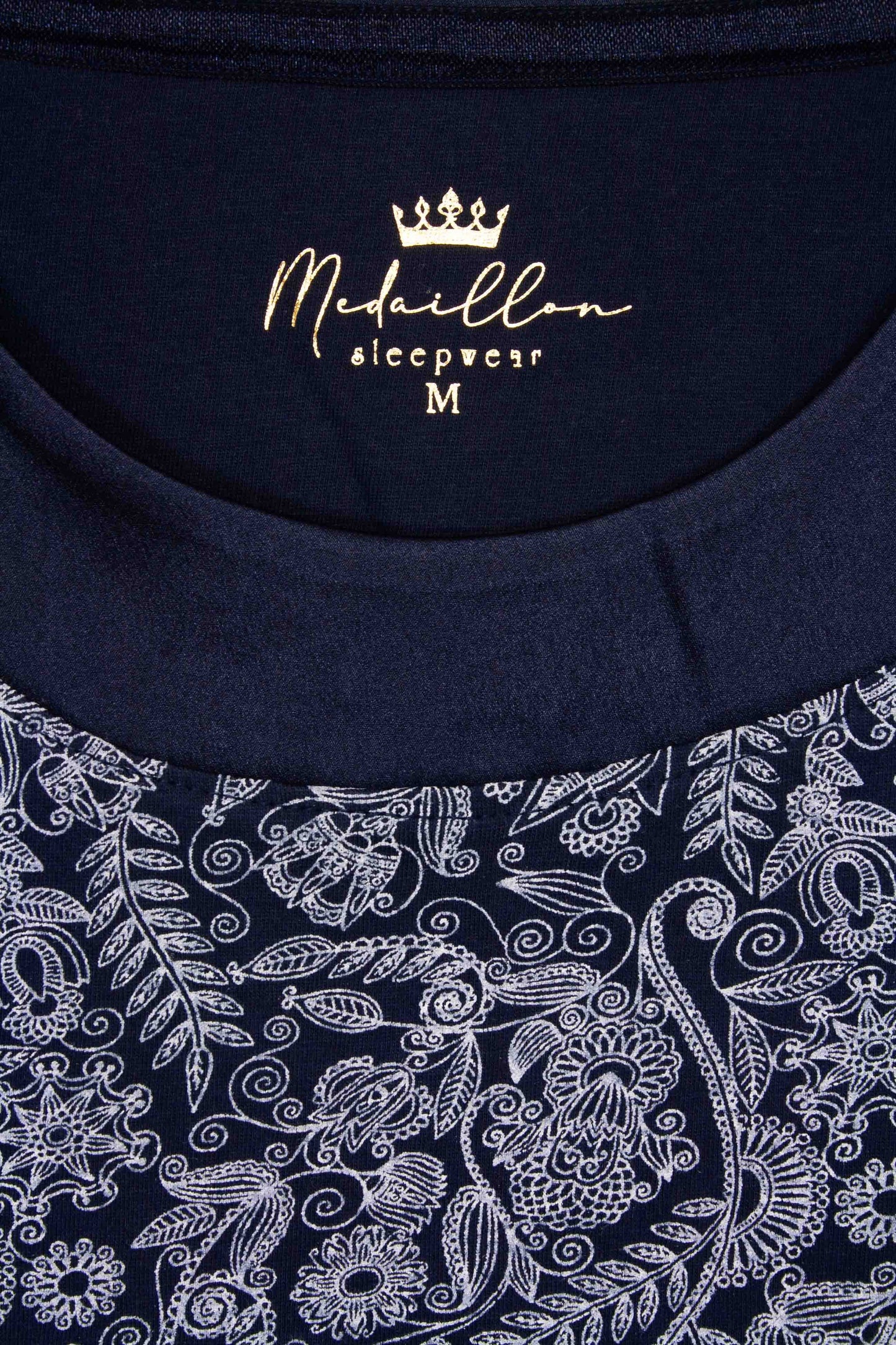 Blauw nachthemd met ronde hals en korte mouwen, versierd met wit geprint bloemen- en bladpatroon.