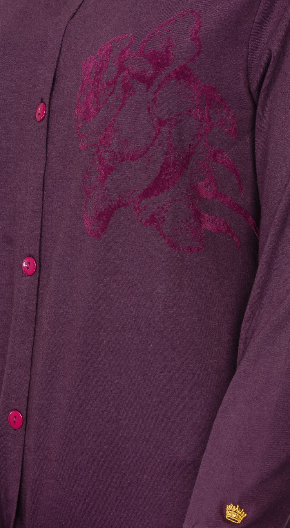 Donkerpaars nachthemd met lange mouwen, doorknoopsluiting en roze flock print op de borst. Gouden kroon embleem onderaan.