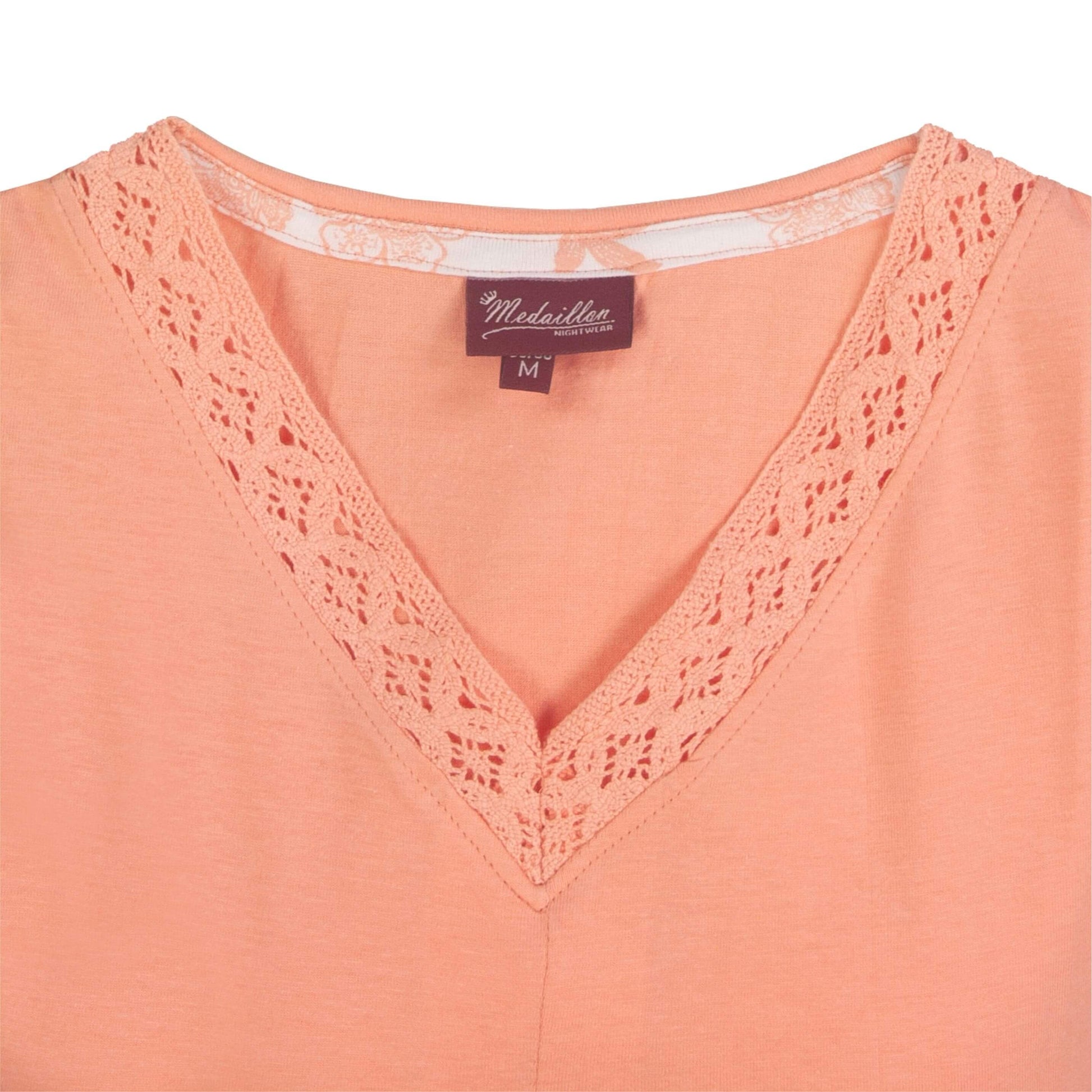 Oranje dames nachthemd met V-hals, afgewerkt met kant. Korte mouwen en een merklogo van Medaillon zichtbaar.