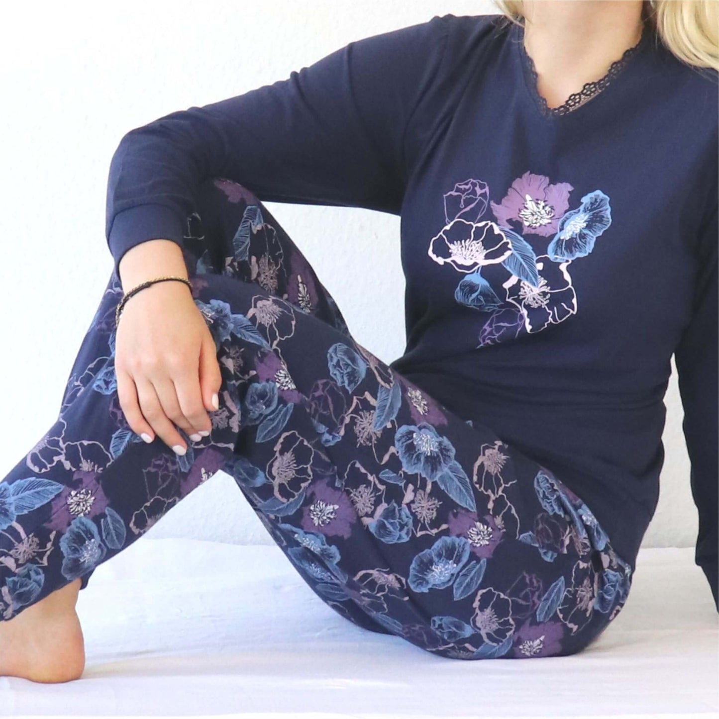 Dames pyjama in donkerblauw met paarse en blauwe bloemenprint op shirt en broek, gemaakt van katoen jersey.