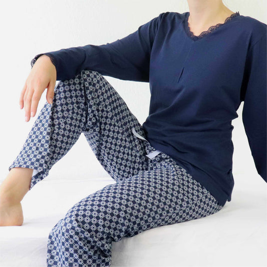 Dames pyjama set met navy blauwe top en gedessineerde broek in katoen jersey, lace detail op mouwen en hals.