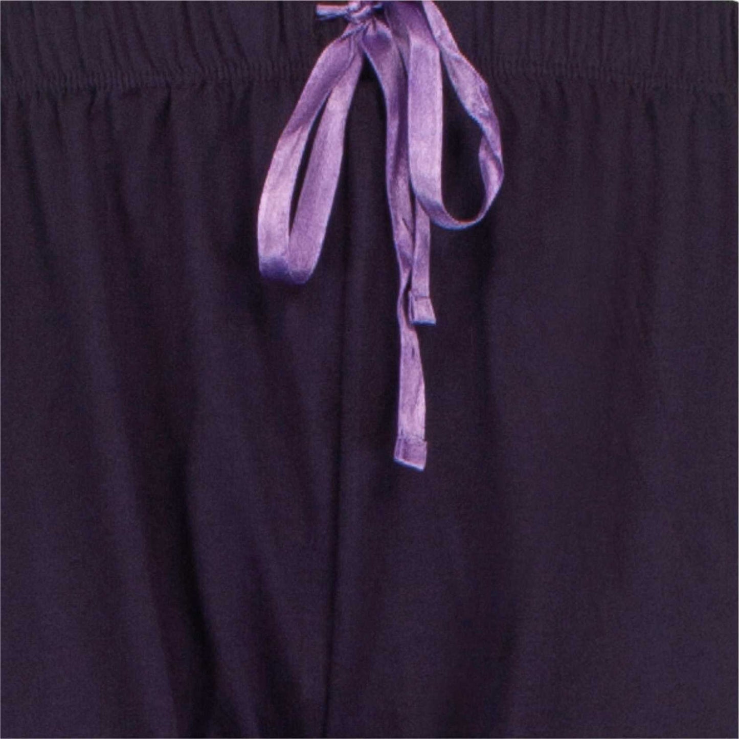 Close-up van een paarse pyjama met een zichtbare polo sluiting en een lila lint dat losjes hangt.
