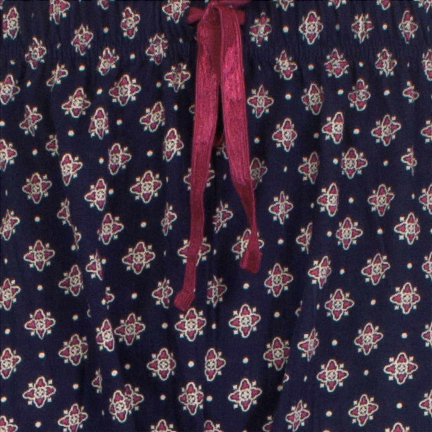 Donkerblauwe pyjamastof met klein rood bloemenpatroon en een rode strik of lint zichtbaar