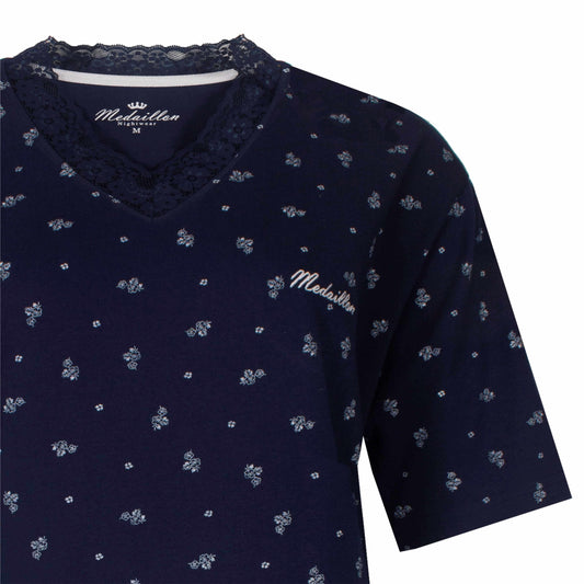 Donkerblauwe dames shortama met kleine witte bloemenprint en kanten V-hals, merk Medaillon zichtbaar op borst.