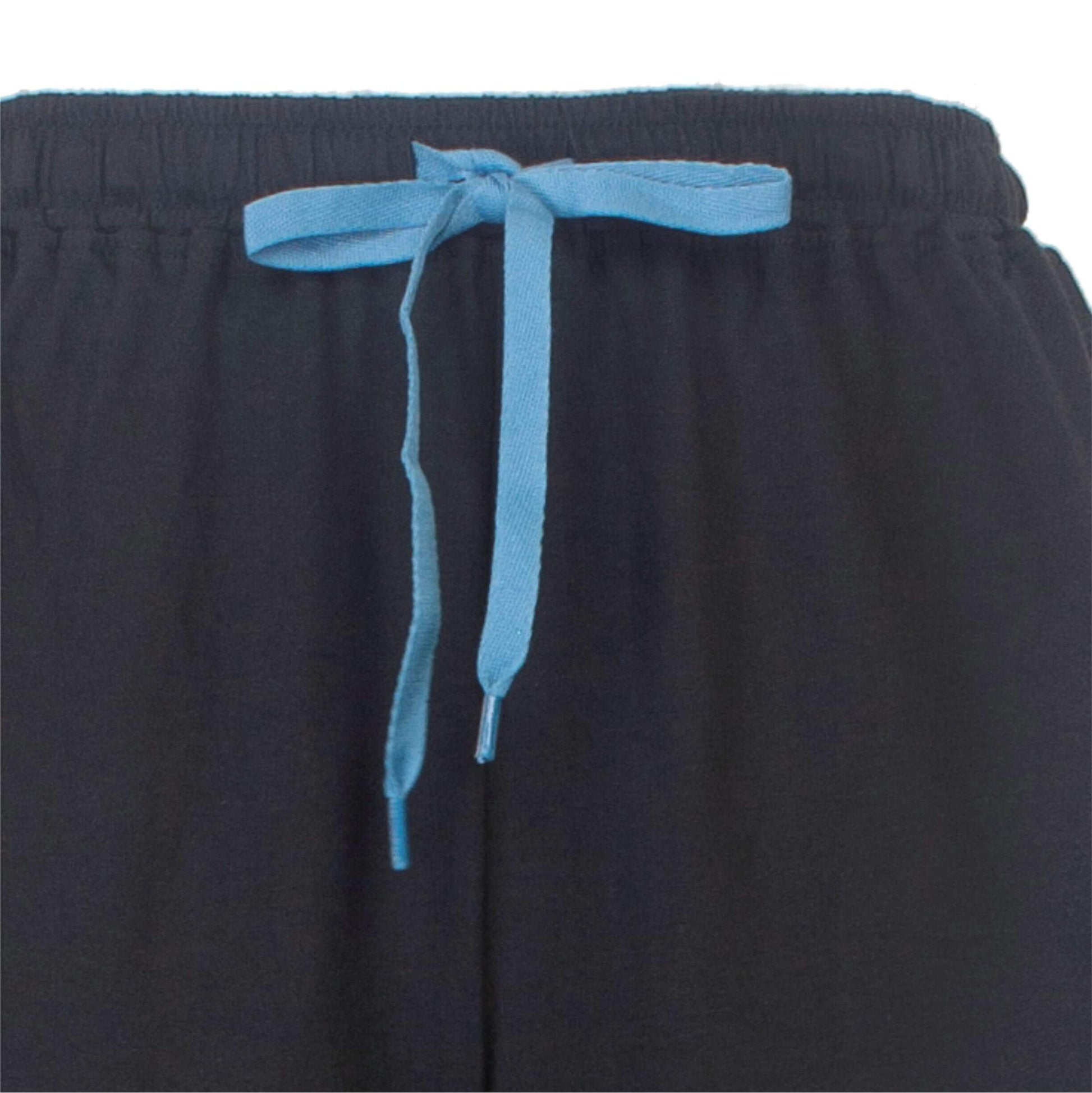 Close-up van een zwarte pyjamabroek met een lichtblauwe trekkoord aan de taille.