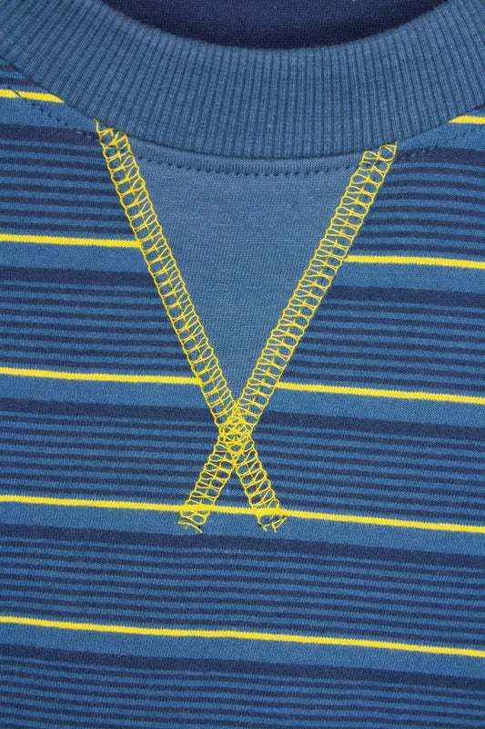 Close-up van een blauwe gestreepte pyjama met gele stiksels in V-vorm op de hals en gele strepen op de stof.