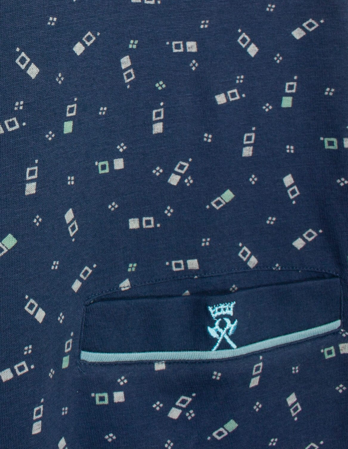 Blauwe pyjama stof met witte en lichtgroene geometrische patronen en een borstzakje met logo.