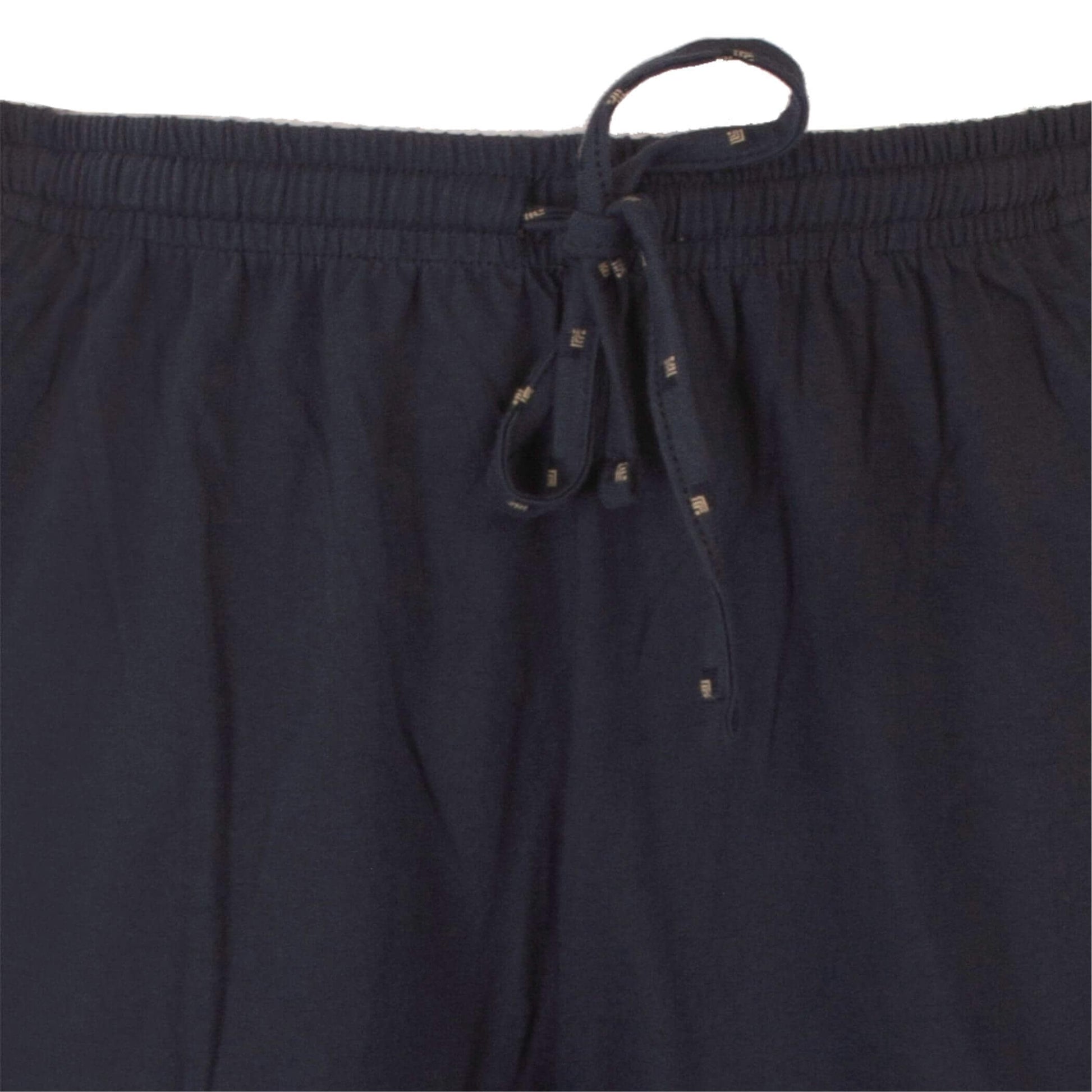 Close-up van een donkerblauwe pyjama broek met elastische tailleband en aantrekkoord met metalen uiteinden.