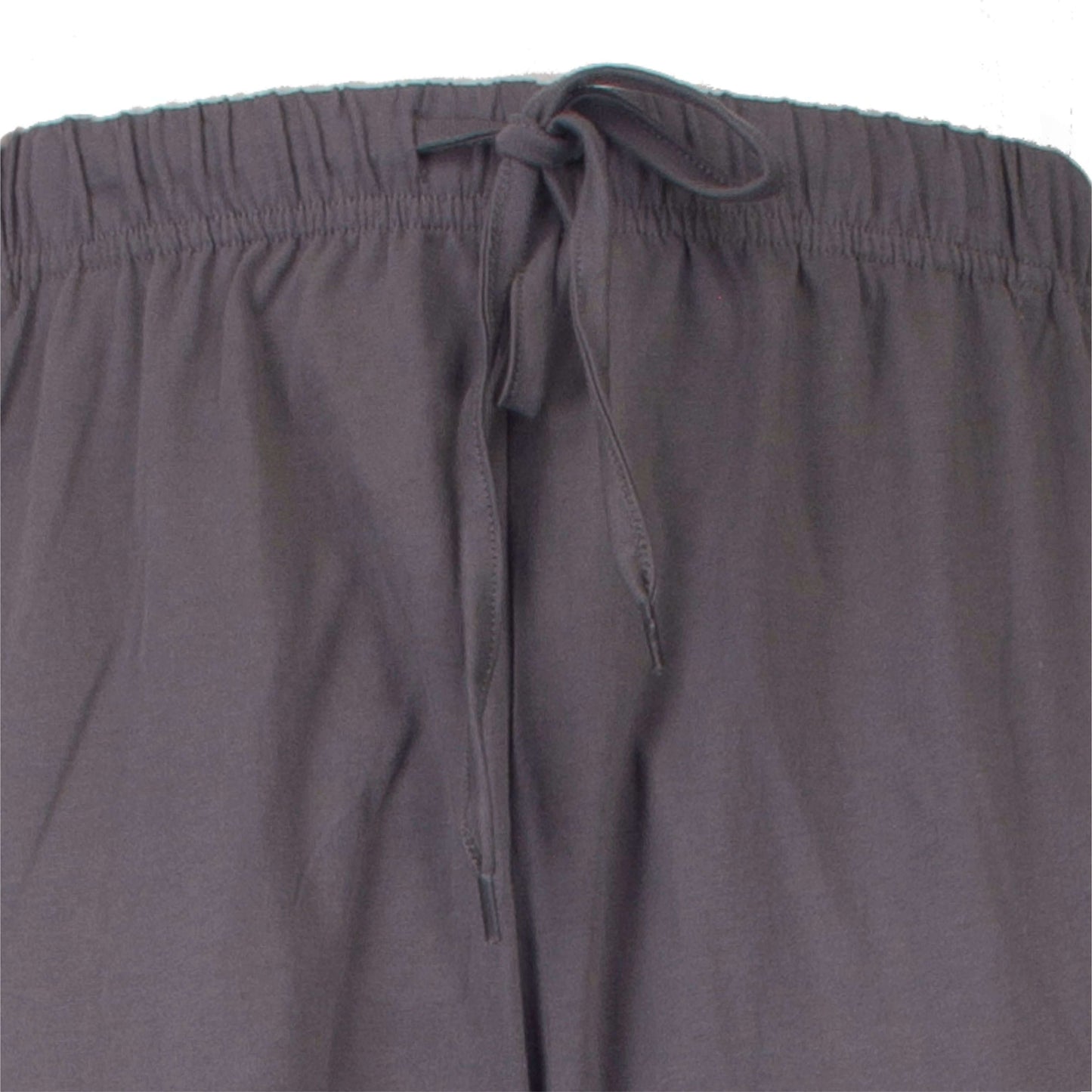 Close-up van een grijze pyjama broek met elastische tailleband en aantrekkoord, gemaakt van zacht materiaal.