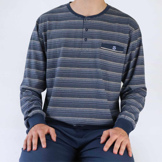 Blauwe gestreepte pyjama top met lange mouwen, ronde hals, knoopsluiting en borstzakje. Effen blauwe broek.