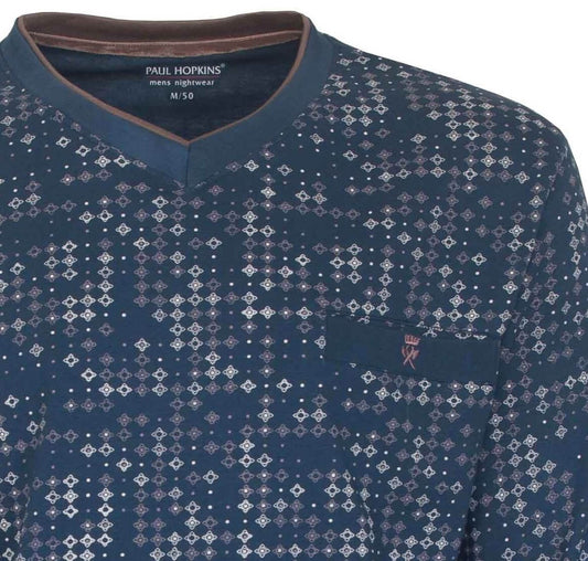 Blauwe pyjama top met V-hals en een patroon van kleine witte en paarse vierkantjes over het hele oppervlak.