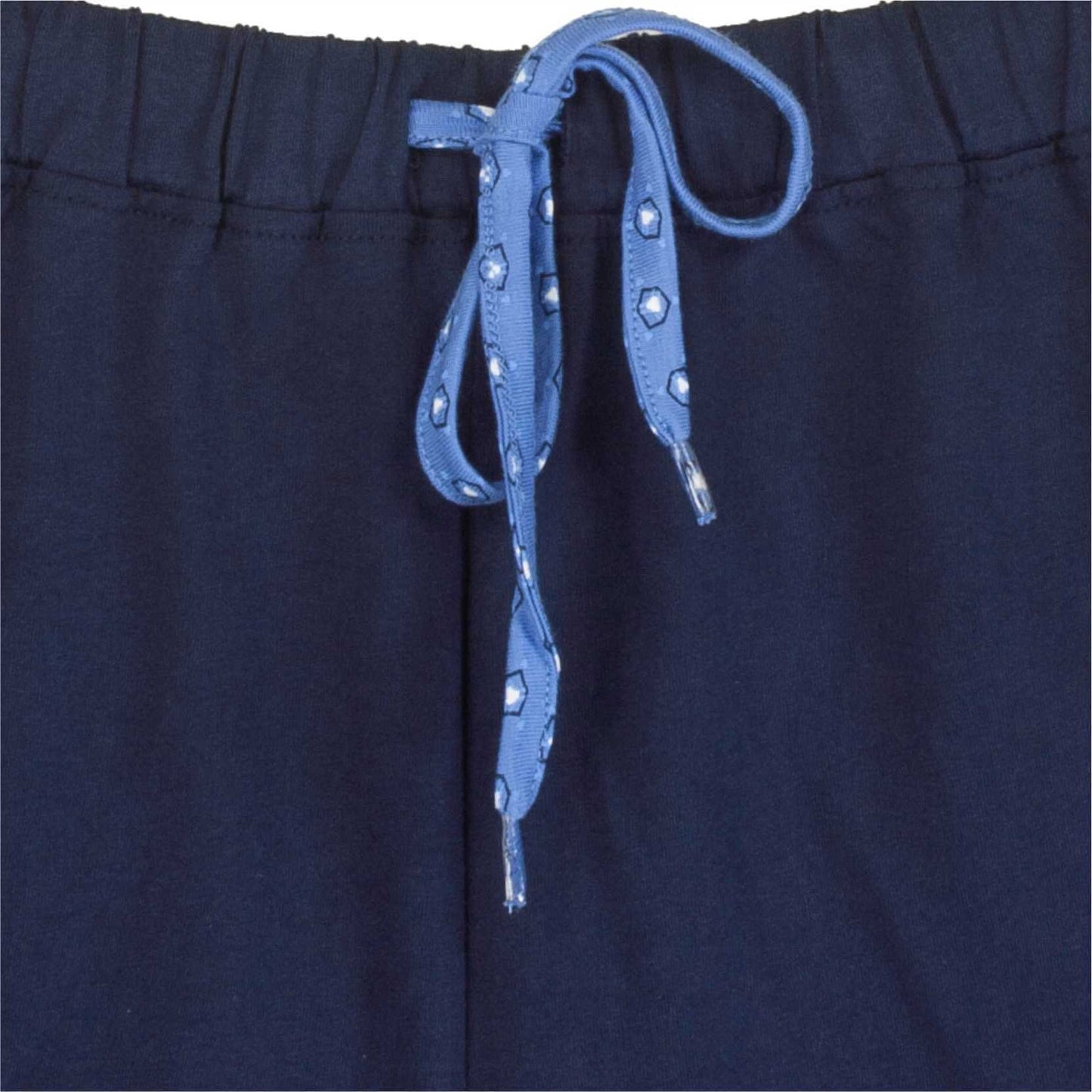 Close-up van donkerblauwe pyjama broek met lichtblauw koord met zilveren hexagonale studs
