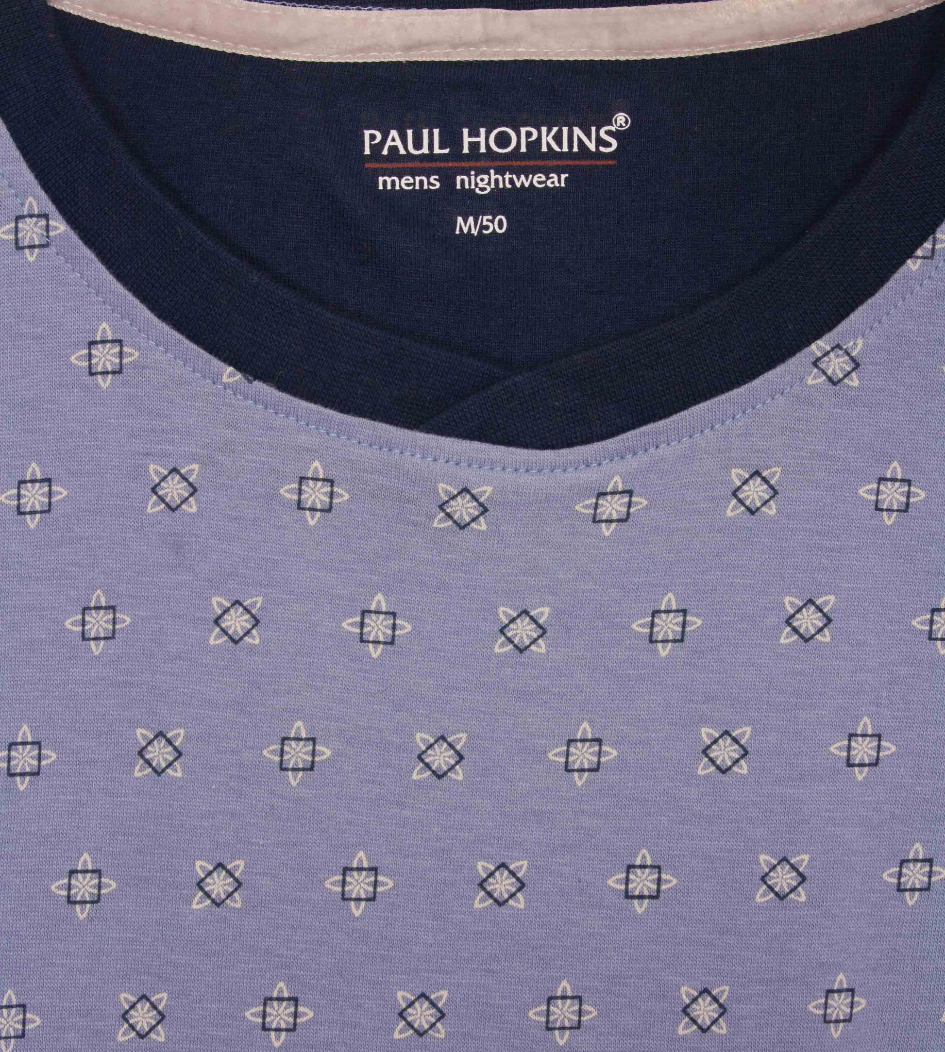 Lichtblauwe pyjama top met ronde hals en geometrisch sterpatroon. Paul Hopkins logo zichtbaar op donkerblauw label.