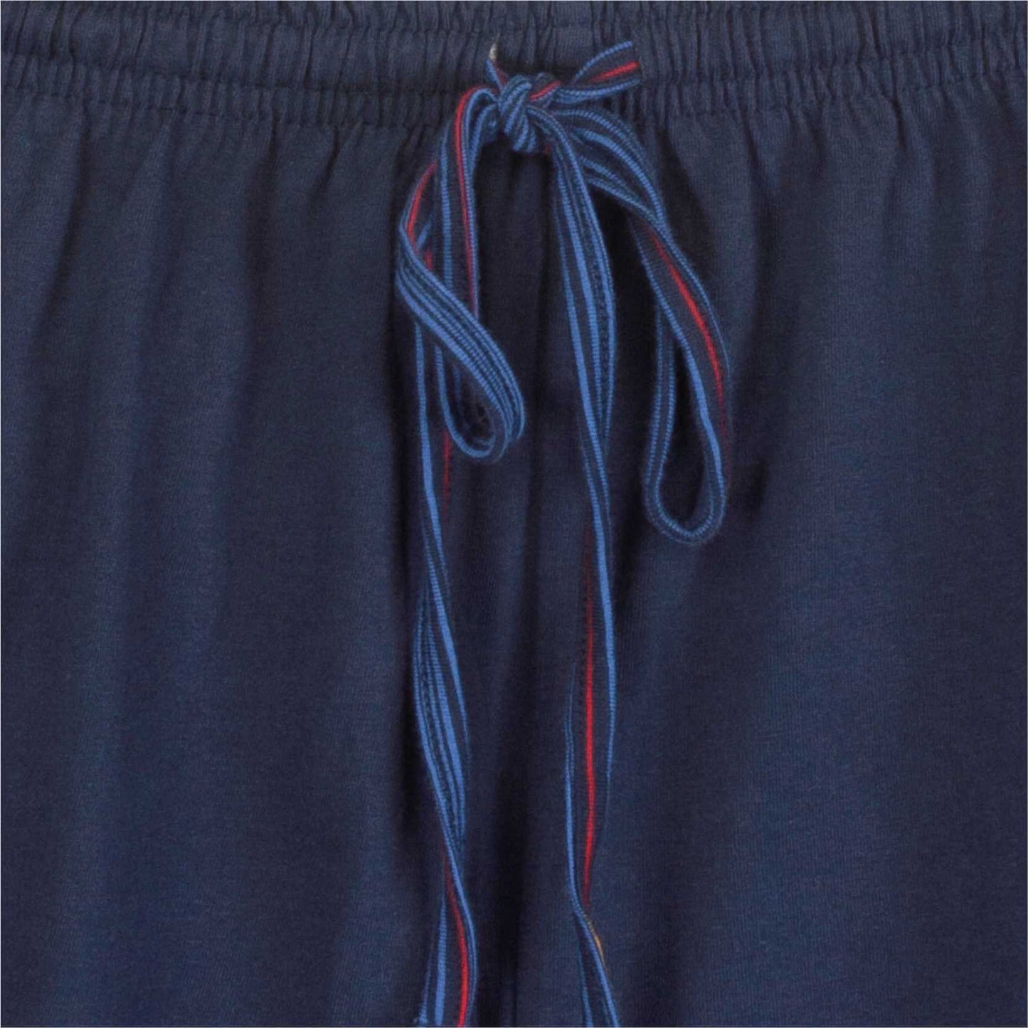 Close-up van een donkerblauwe pyjama broek met blauw en rood gestreept koord als tailleband
