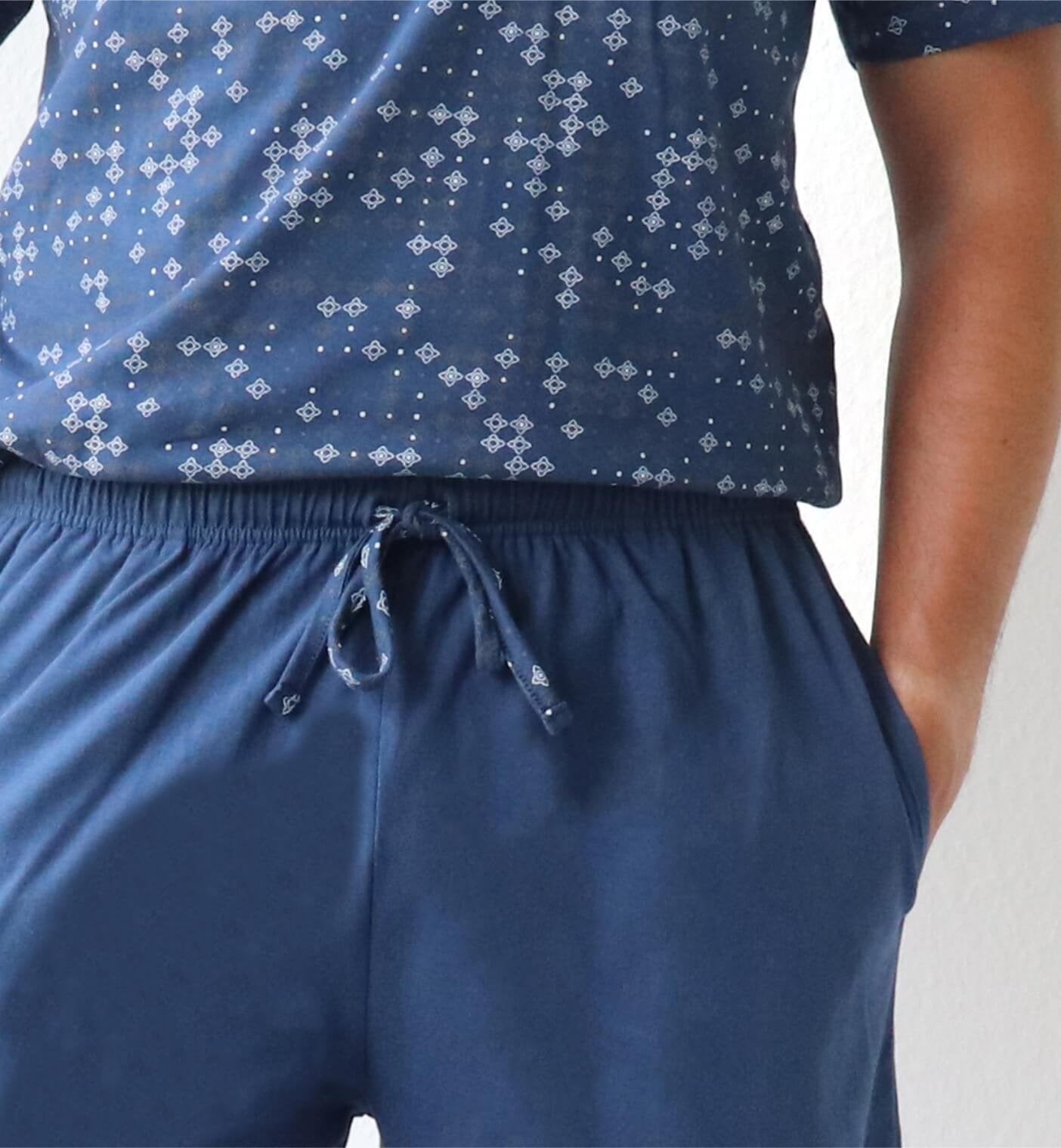 Close-up van een blauwe heren shortama met wit patroon op het shirt en een effen blauwe korte broek met trekkoord.