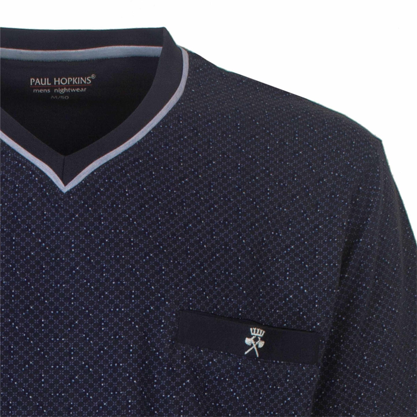 Close-up van een donkerblauwe pyjama top met V-hals en subtiel stippenpatroon, Paul Hopkins logo zichtbaar.