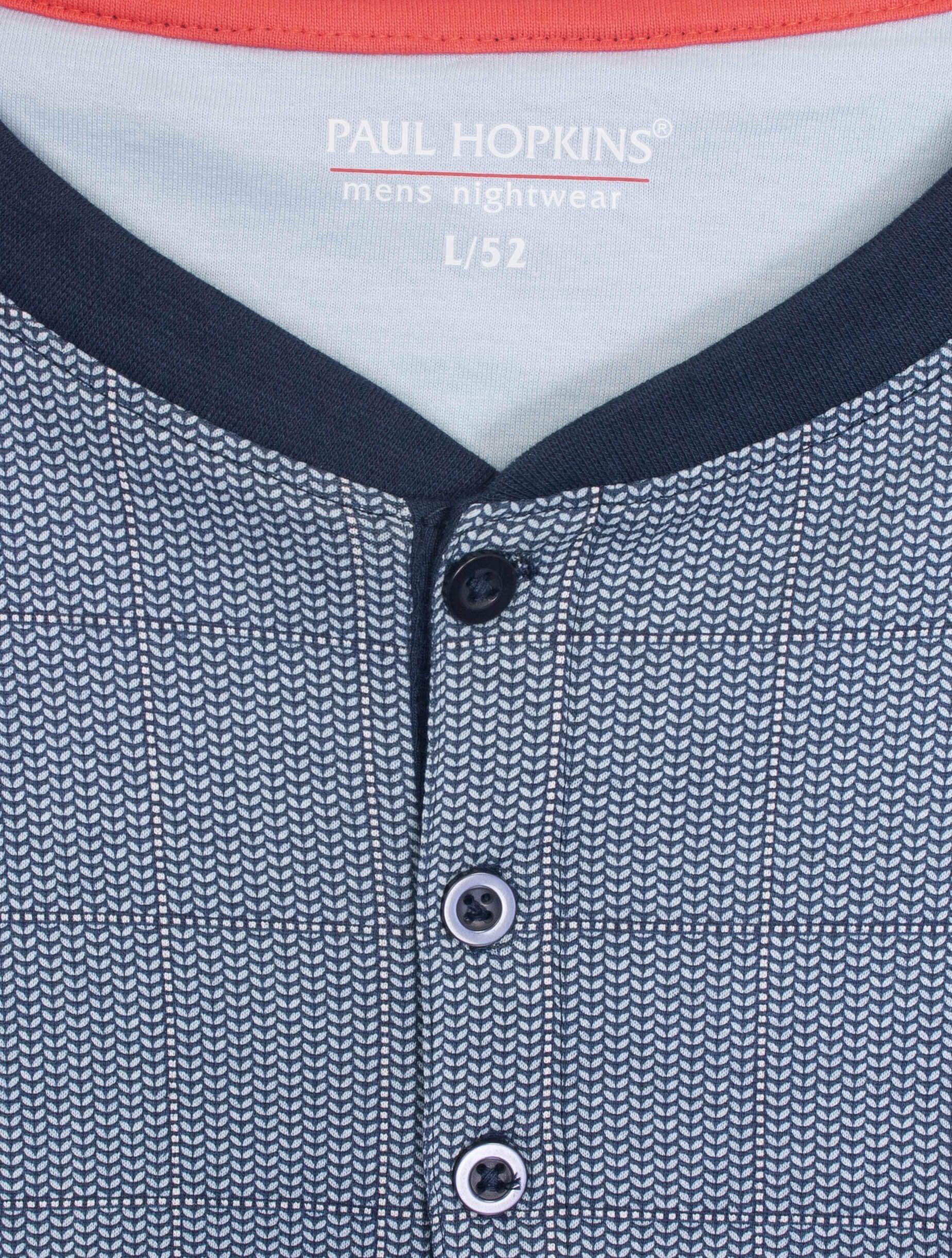 Blauwe heren pyjama top met geprint dessin, knoopsluiting en logo. Witte merkdetails zichtbaar op de kraag.