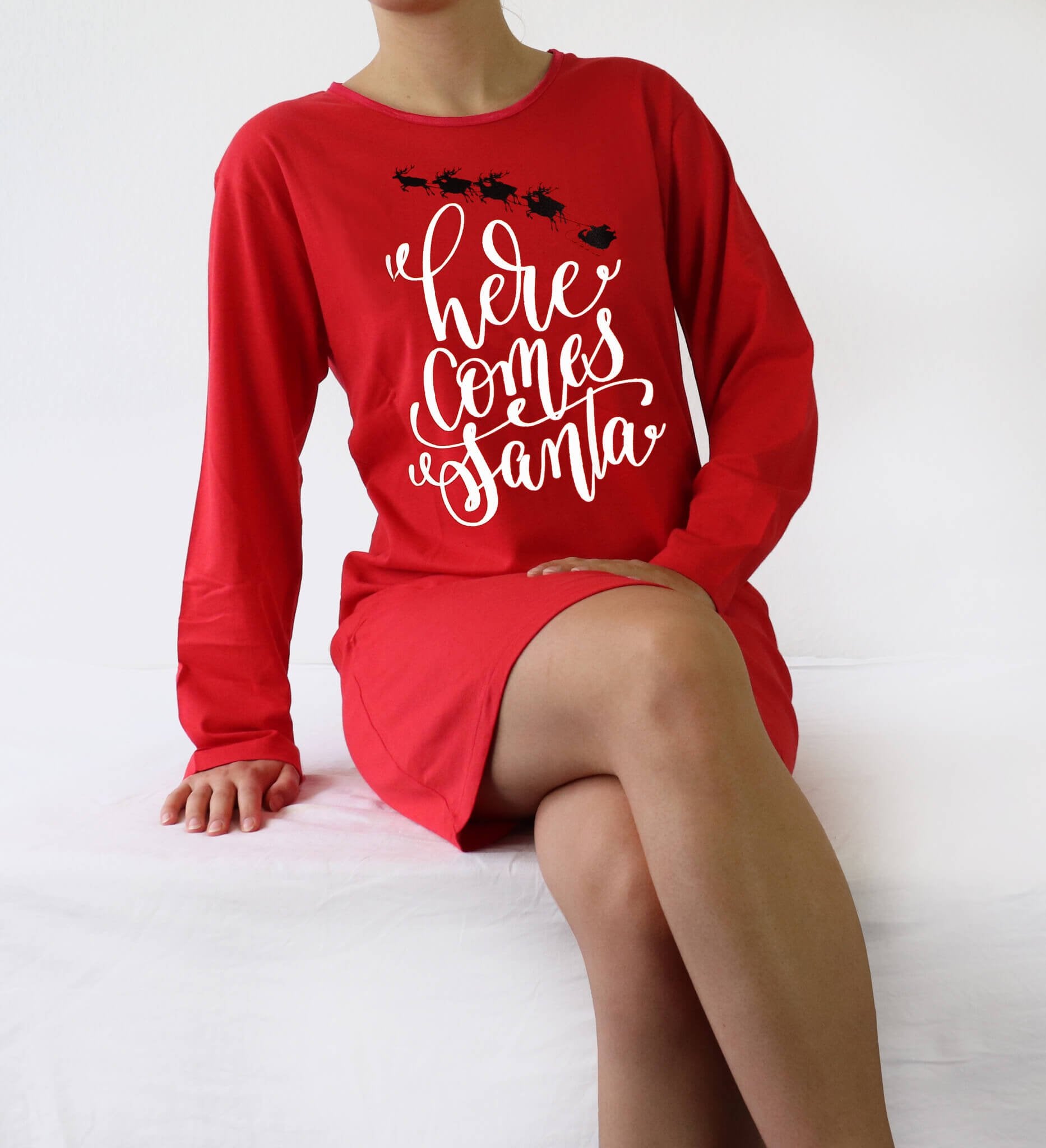 Rood nachthemd met lange mouwen en witte tekst 'Here comes Santa' en zwarte arreslee afbeelding