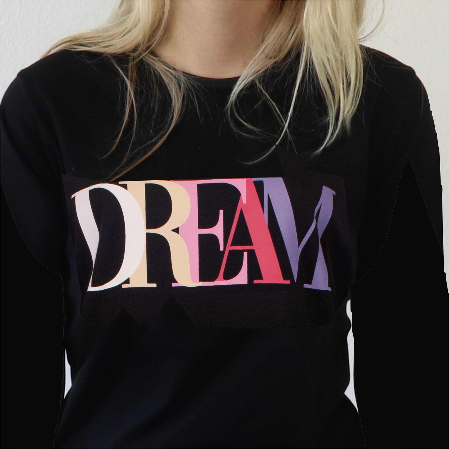 Zwart nachthemd met lange mouwen, 'DREAM' in kleurrijke letters op de borst, gedragen door iemand met blond haar.