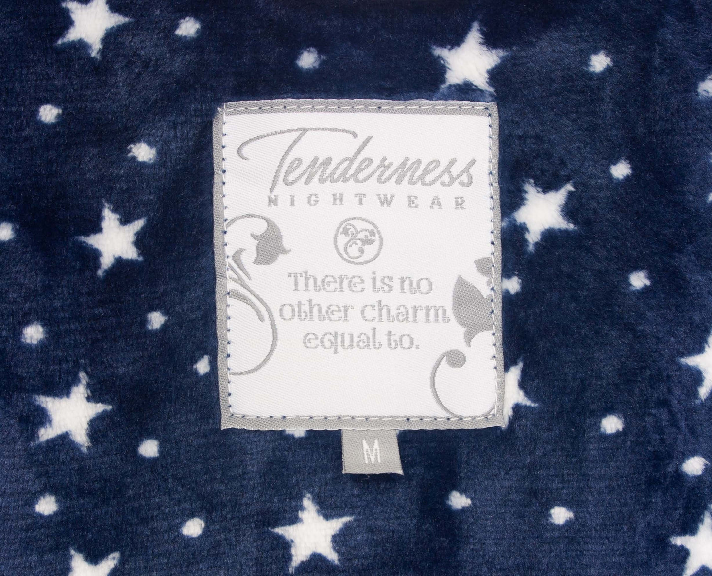 Blauwe fleece badjas met witte sterren. Label toont 'Tenderness Nightwear' en een inspirerende tekst.