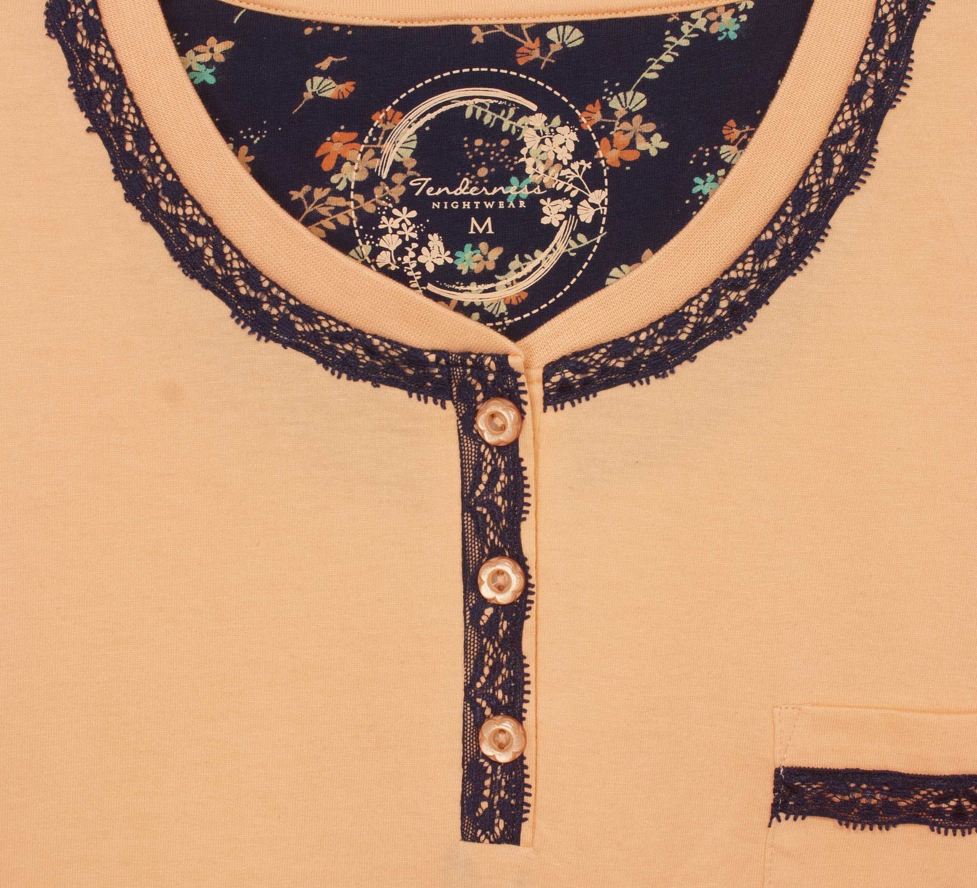 Koraal nachthemd met zwarte kanten afwerking, ronde hals, polosluiting en borstzakje. Bloemenprint op binnenkant hals.