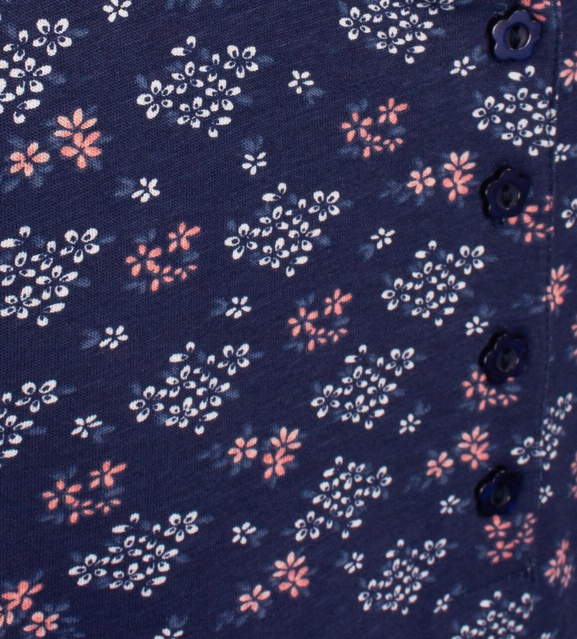 Blauwe pyjamastof met witte en roze bloemenprint. Zichtbare knoopsluiting aan de rechterkant.