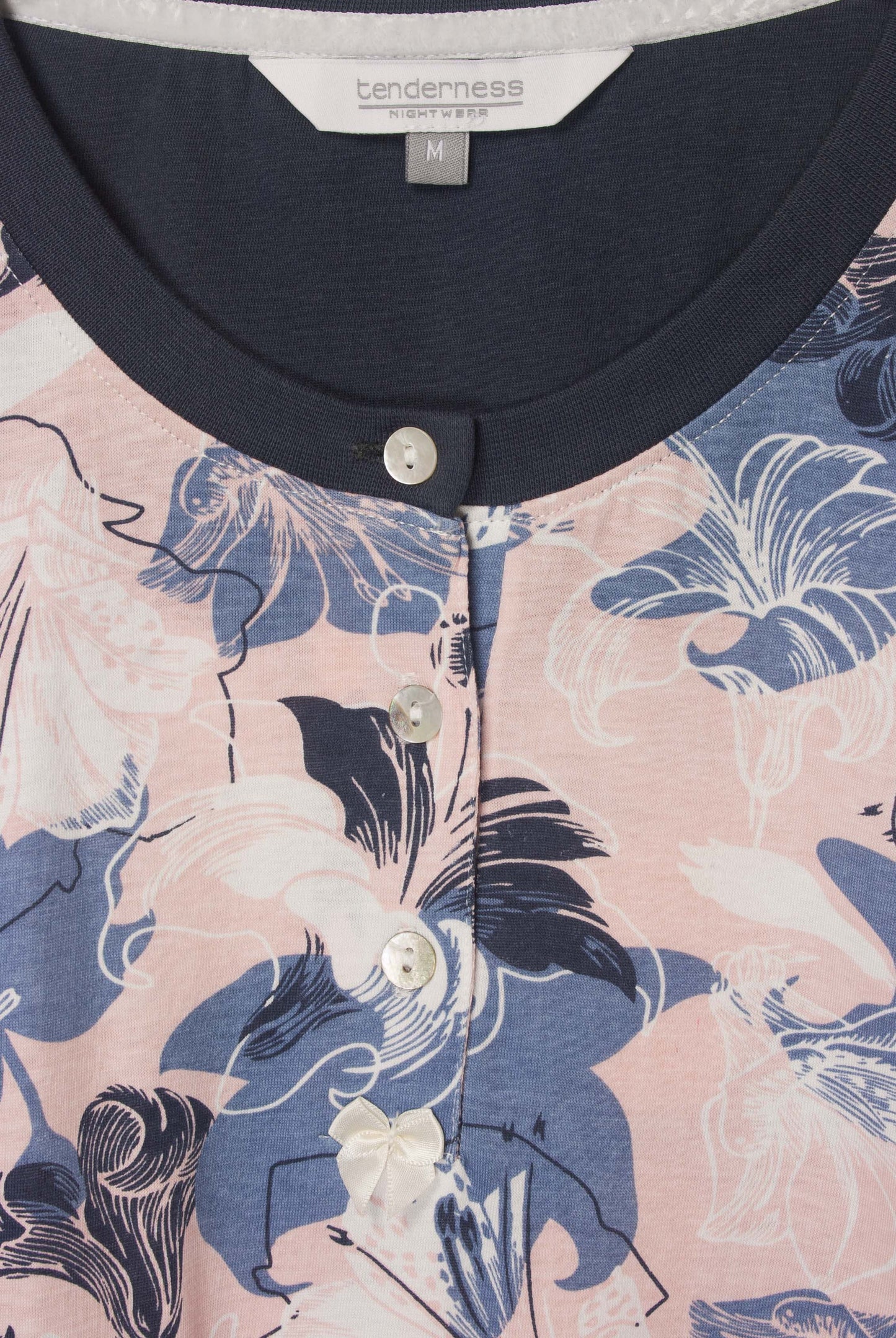 Donkerblauwe dames pyjama met roze en blauwe bloemenprint, polo sluiting en witte knopen en strikje.