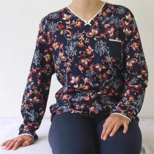 Donkerblauwe dames pyjama met rode en gele bloemenprint, lange mouwen en V-hals met wit accent.
