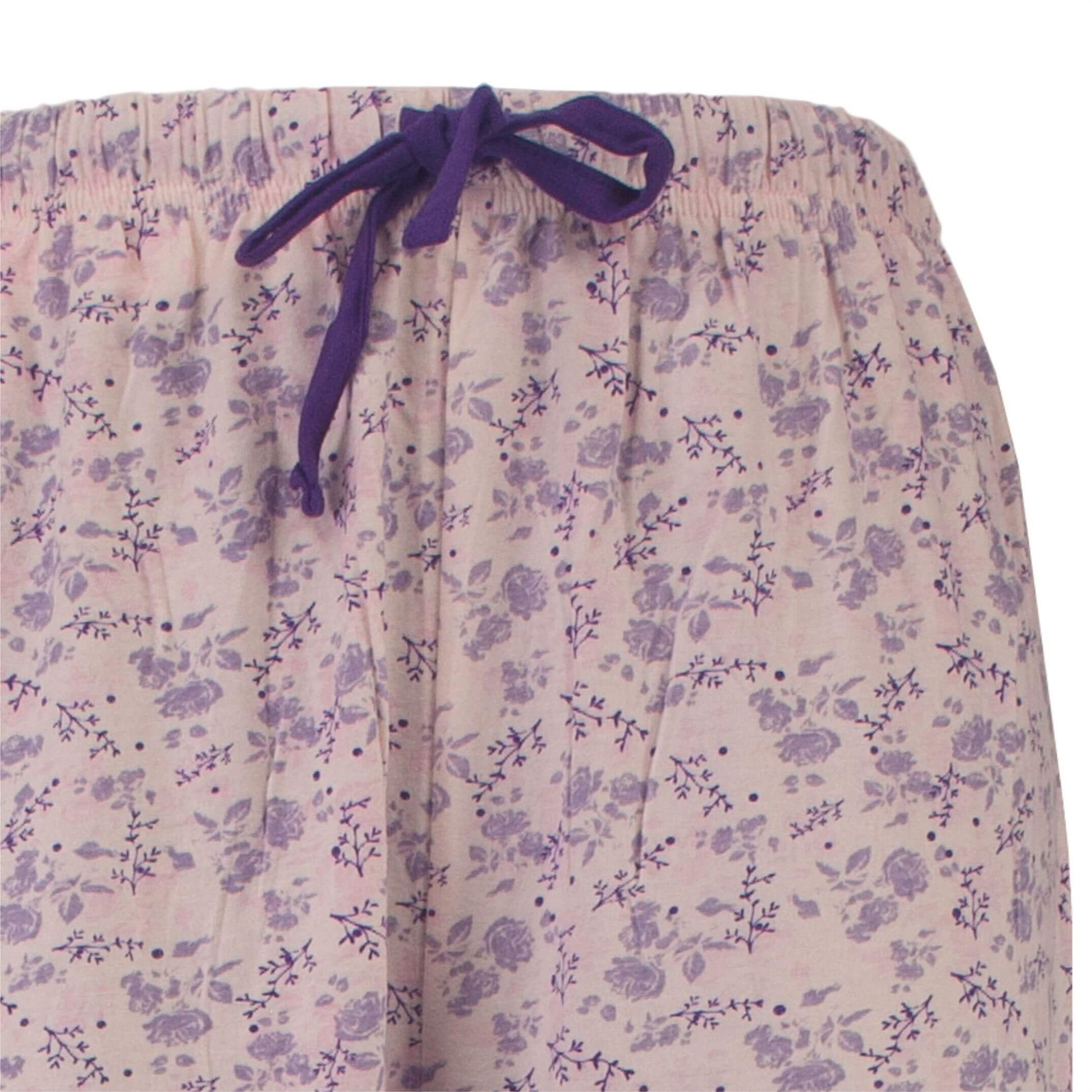 Paarse capribroek van een pyjama met lichtroze achtergrond en paars bloemenpatroon, voorzien van een aantrekkoord.
