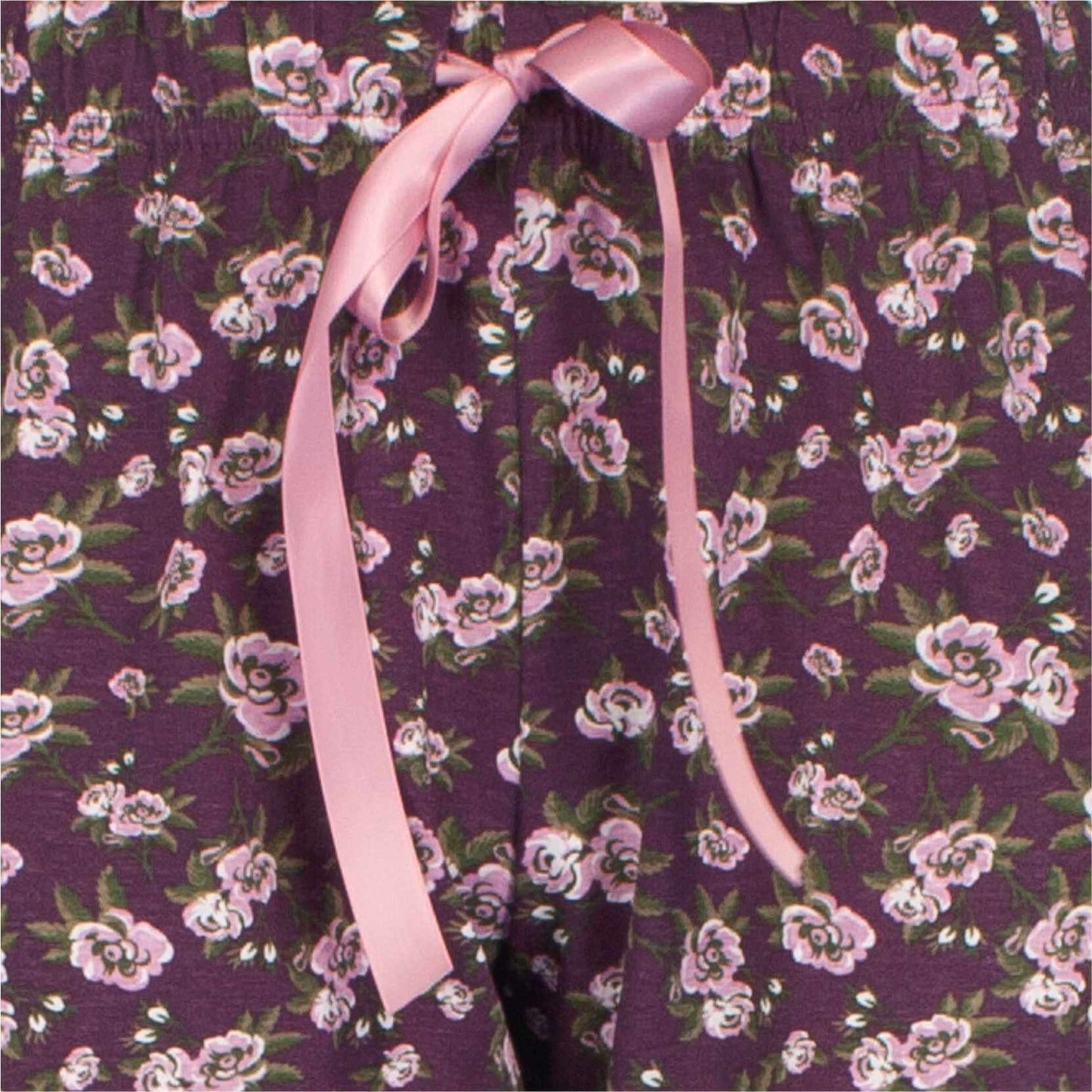 Paarse pyjama met roze bloemenprint en een roze lint vastgemaakt aan de kraag