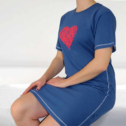 Blauw nachthemd met rood hart-motief, korte mouwen en contrasterend stiksel, gedragen door een zittende vrouw.