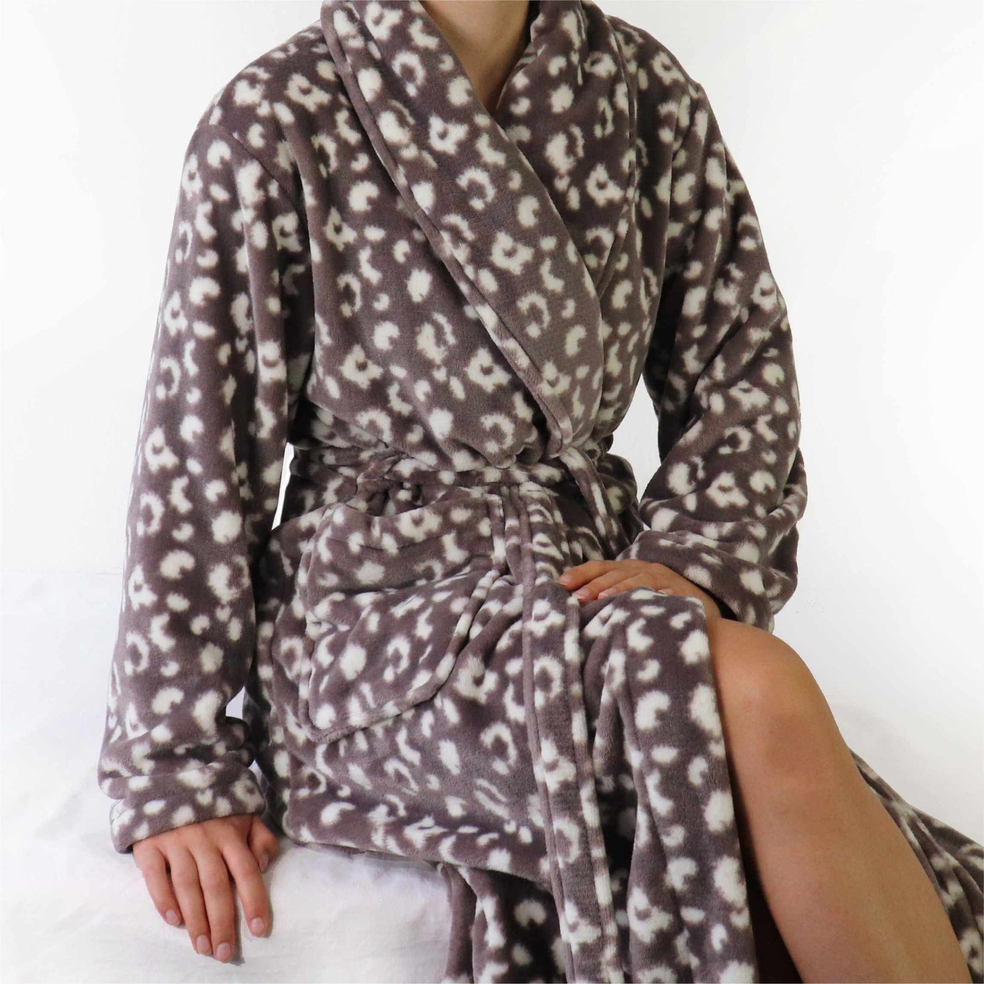 Zachte fleece oine damesochtendjas met witte panterprint, geknoopt met een cevers en lange mouwen.