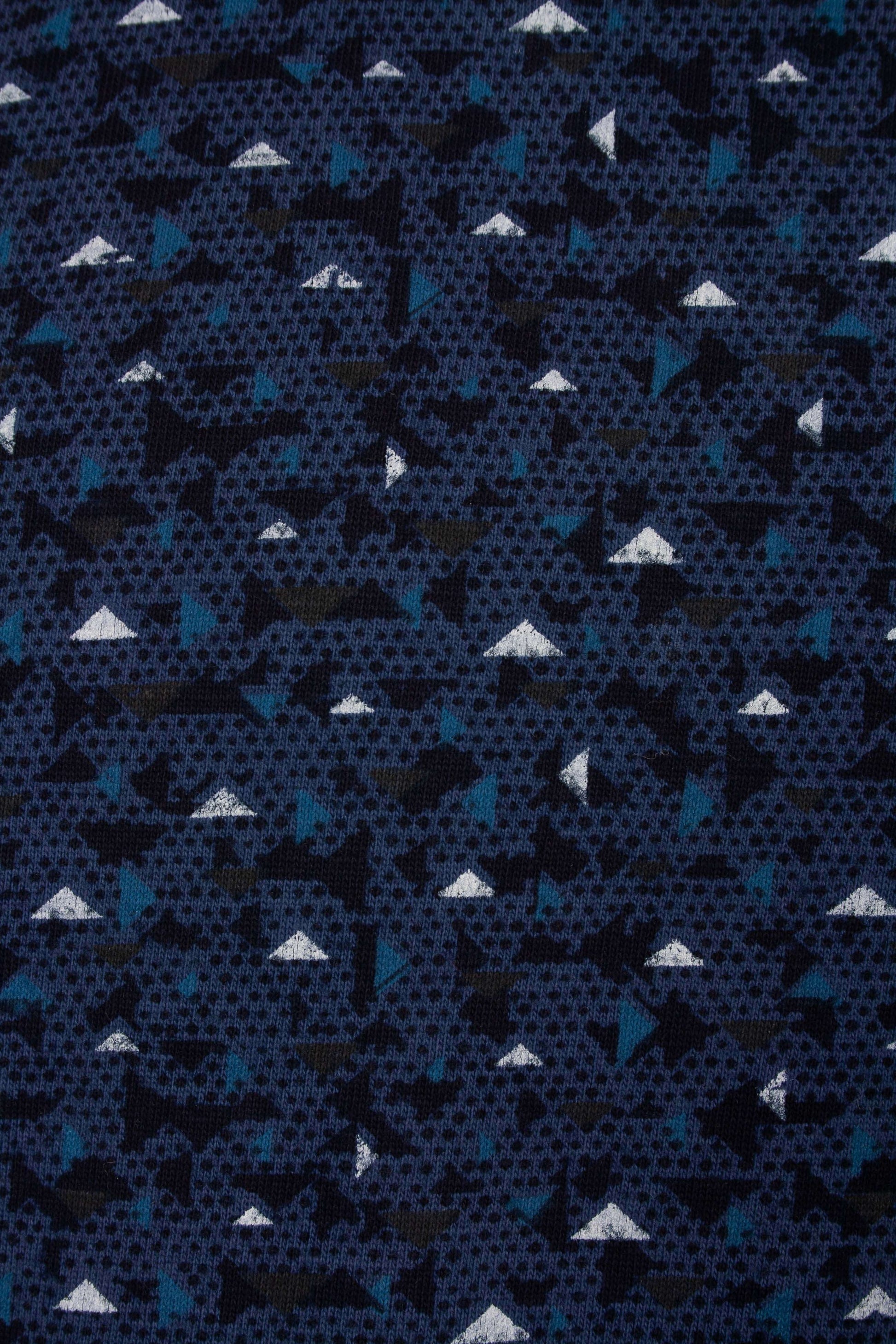 Donkerblauwe stof met geometrisch patroon van witte driehoekjes en lichtblauwe vormen, ideaal voor pyjama's.
