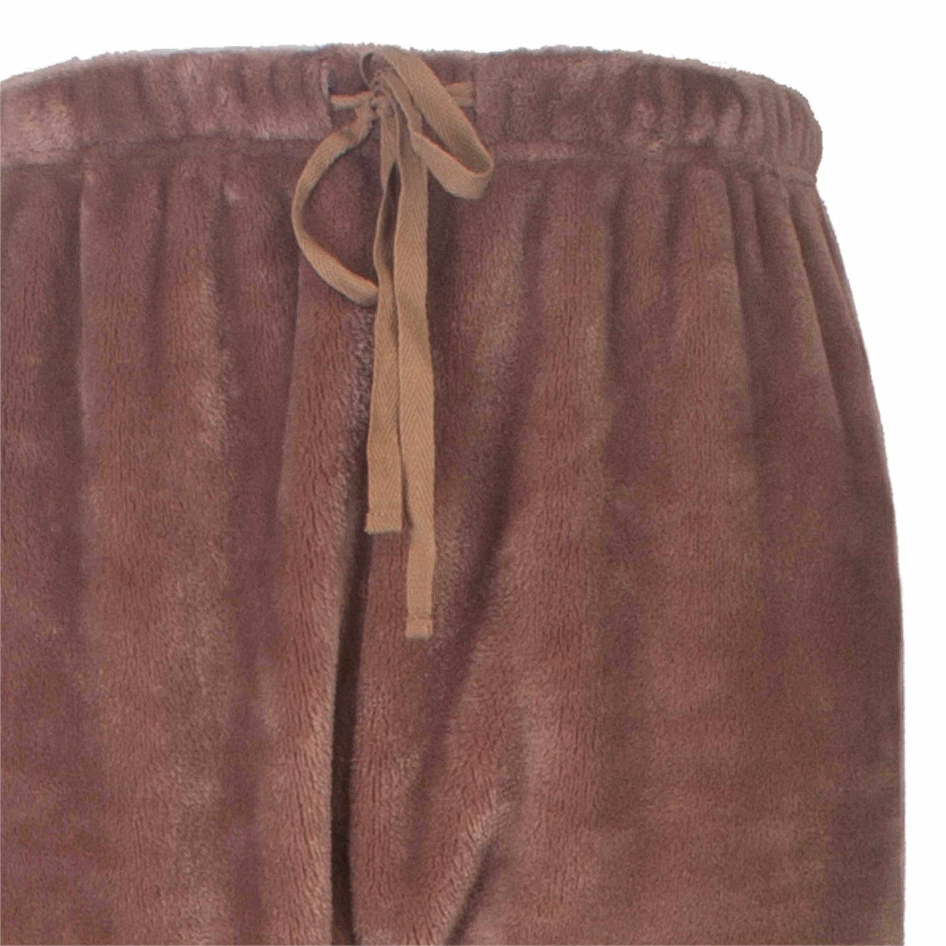 Close-up van bruine fleece stof met elastische tailleband en beige trekkoord, deel van een huispak.