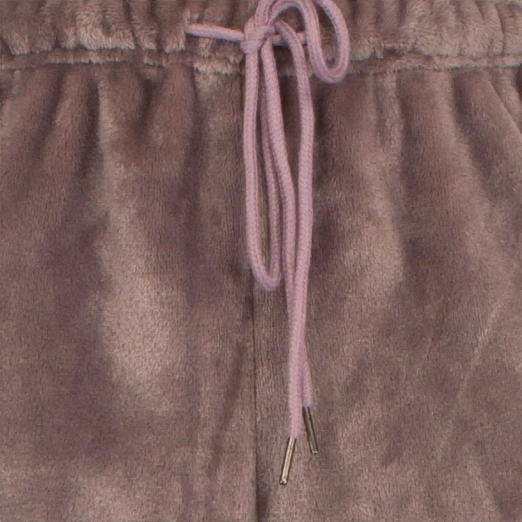 Close-up van bruine fleece stof met roze koord, detail van een huispak met panterprint