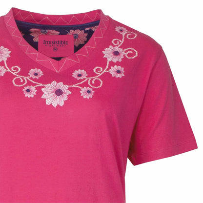 Roze nachthemd met V-hals en korte mouwen, versierd met witte bloemen en krullen borduurwerk rond de hals