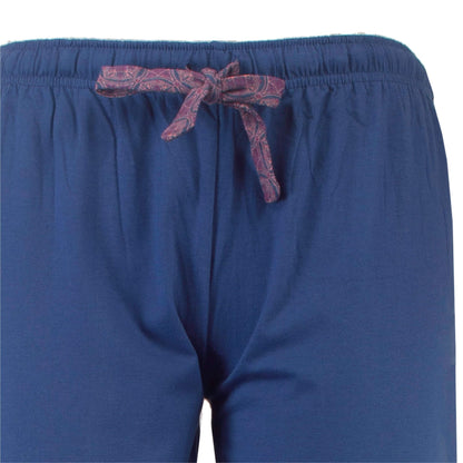 Close-up van een blauwe pyjamabroek met een decoratief rood koord met patroon in de taille