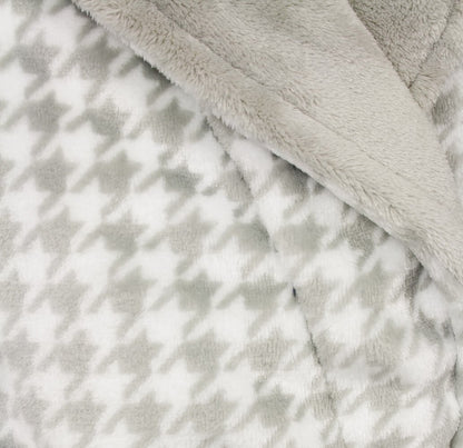 Close-up van zachte grijze fleece stof met pied-de-poule patroon, gedeeltelijk bedekt door effen fleece.