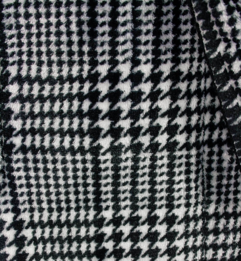 Close-up van zwart-wit geruite stof met houndstooth patroon, typisch voor een fleece badjas.