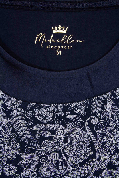 Blauw nachthemd met ronde hals en korte mouwen, versierd met wit geprint bloemen- en bladpatroon.