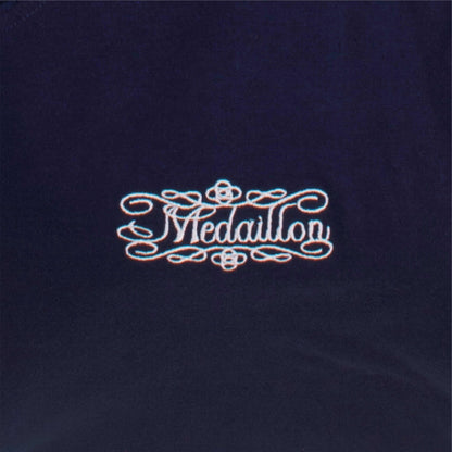 Elegant logo 'Medaillon' in sierlijke letters op donkerblauwe achtergrond, omringd door decoratieve krullen.