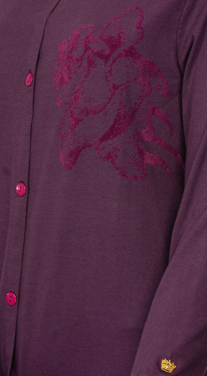 Donkerpaars nachthemd met lange mouwen, doorknoopsluiting en roze flock print op de borst. Gouden kroon embleem onderaan.